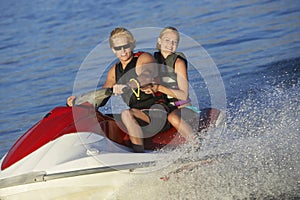 Young Couple Riding PWC On Lake