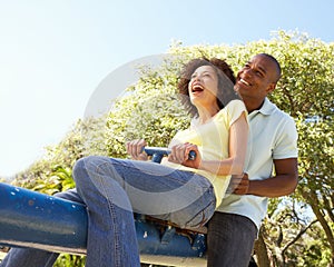 Young Couple Riding On SeeSaw In Park photo