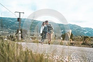 Young couple riding a skateboard on a road. Concept of millenials Skateboarders