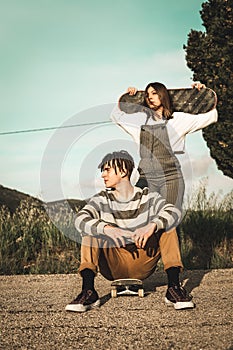 Young couple riding skateboarding having fun. Modern skateboarders millennials