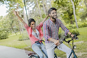 Young couple riding on the tandem bicycle