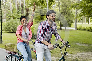 Young couple riding on the tandem bicycle