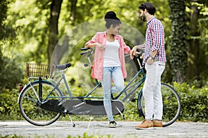 Young couple riding on the tandem bicycle