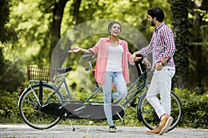 Young couple riding on the tandem bicycle