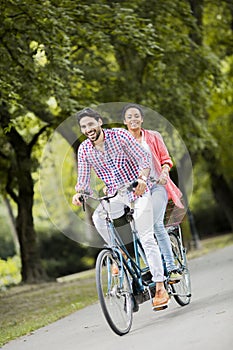 Young couple riding on the tandem bicycle