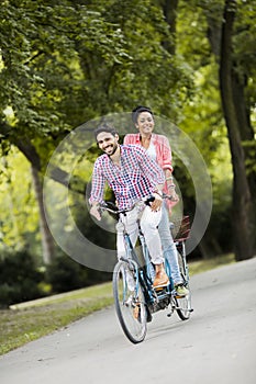 Young couple riding on the tandem bicycle