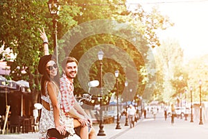 Young couple riding a vintage scooter in the street