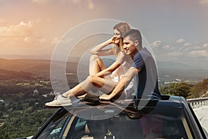 Young couple on road trip travel by car together and enjoy the nature view from the top