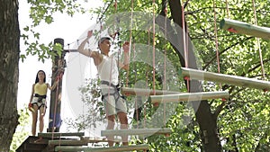 Young couple on a rope climbing in the adventure park