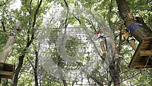 Young couple on a rope climbing in the adventure park