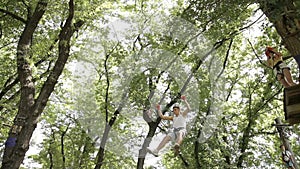 Young couple on a rope climbing in the adventure park