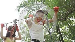 Young couple on a rope climbing in the adventure park