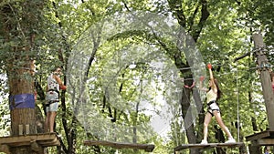 Young couple on a rope climbing in the adventure park