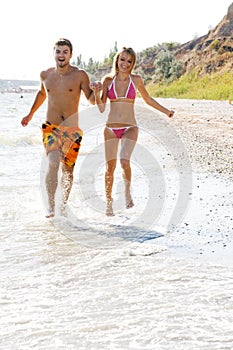 Young couple running along the beach