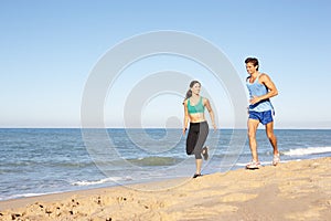 Young Couple Running Along Beach