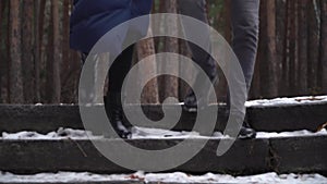 Young couple running down the stairs in winter park. Clouse-up of couple`s feet.