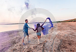 Young couple running with hand flare or fusee