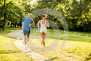 Young couple running in the park on a sunny day