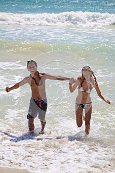 Young couple runs out of the ocean