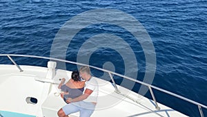 Young couple sail on a white yacht on the sea, vacation at sea