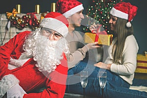 Young couple with Santa celebrating New Year 2017, Christmas