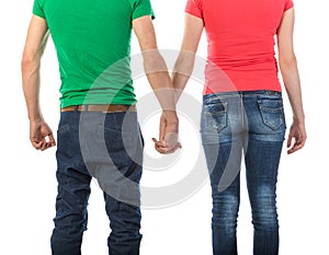 Young couple seen from behind holding hands