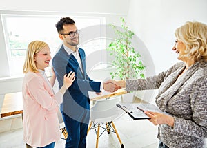 young couple shaking hands deal contract real estate investment business agreement agent handshake signing