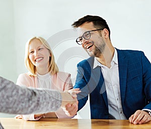 young couple shaking hands deal contract real estate investment business agreement agent handshake signing