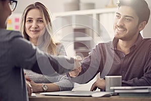 Young couple shaking hands with a female agent