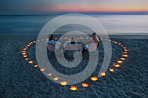 A young couple share a romantic dinner on the beach