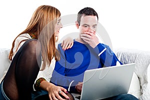 Young couple shocked whilst looking at the laptop