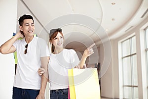 Young couple with shopping bags walking in mall