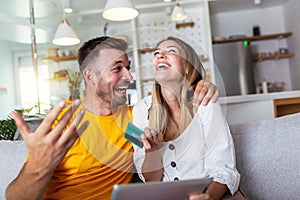 Young couple shopping online with digital tablet and credit card at home