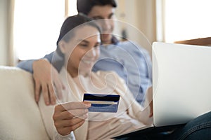 Young couple shopping online on laptop from home