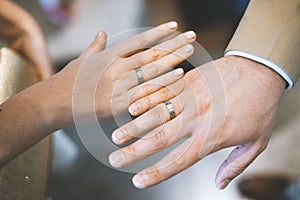Young couple showing hands with wedding rings
