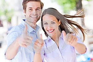 Young couple showing thumbs up