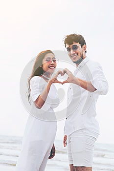 Young couple shows heart shape hand gesture.