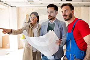 Young couple shows to builder handyman details about renovations