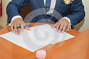 Young couple signing wedding documents.