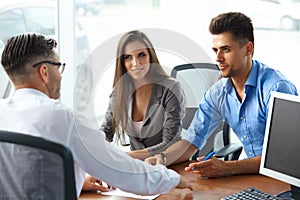 Young Couple Signs a Contract For the Purchase of a New Car