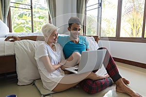 Young Couple Sit Near Bed, Happy Smile Hispanic Man And Woman Using Laptop Computer