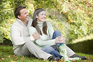 Young couple sitting in autumn woods
