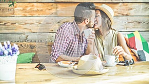 Young couple kissing eachother in a bar and trinking coffe photo