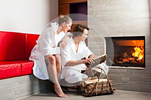 Young couple sitting in bathrobe for fire