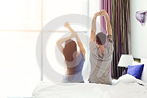 Young couple sitting on bed in hotel room