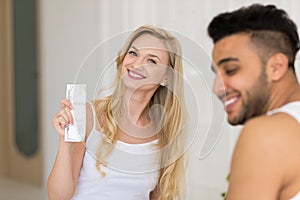 Young Couple Sitting In Bed, Smiling Woman Man Hold Condom Lovers Contraception Protection