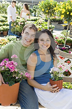 Young couple sitting on bench in garden centre