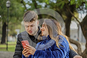 Young couple sitting on a bench in a public park