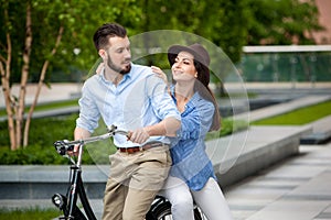 Young couple sitting on a bicycle