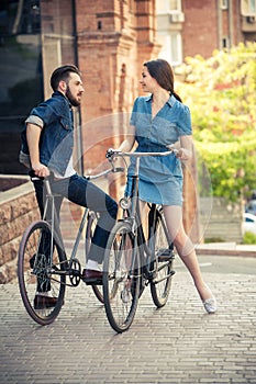 Young couple sitting on a bicycle opposite the